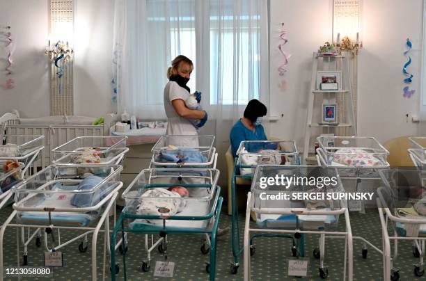 Nurses care for newborn babies at Kiev's Venice hotel on May 15, 2020. - More than 100 babies born to surrogate mothers have been stranded in Ukraine...