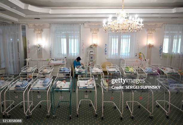 Nurse cares for newborn babies at Kiev's Venice hotel on May 15, 2020. - More than 100 babies born to surrogate mothers have been stranded in Ukraine...