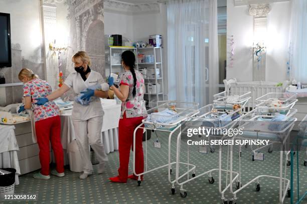 Nurses care for newborn babies at Kiev's Venice hotel on May 15, 2020. - More than 100 babies born to surrogate mothers have been stranded in Ukraine...