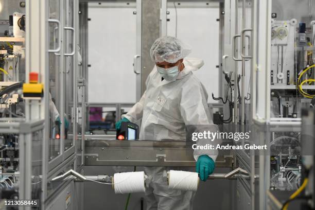 Workers make protective face masks at a newly-launched production line at a BMW factory that normally produces car parts during the novel coronavirus...