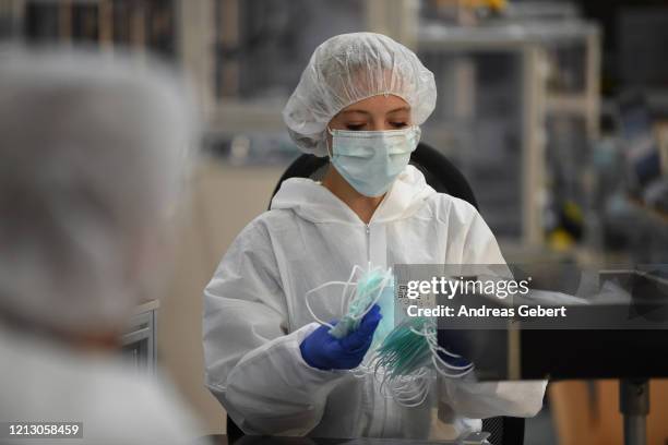 Worker packs protective face masks at a newly-launched production line at a BMW factory that normally produces car parts during the novel coronavirus...