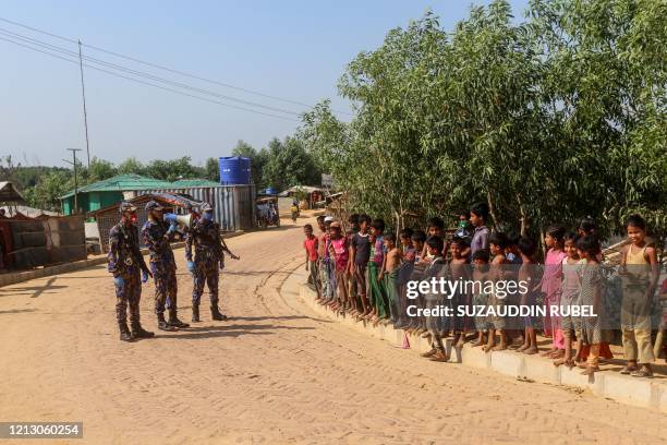 Security personnel use a loudspeaker to raise awareness about the COVID-19 coronavirus in a Rohingya refugee camp in Ukhia on May 15, 2020. -...