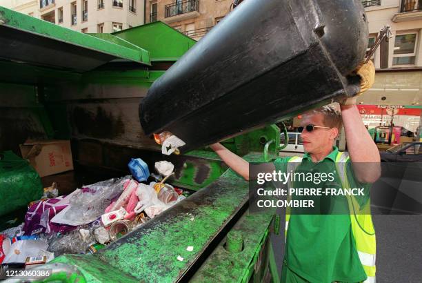 Un employé de la ville de Paris vide une corbeille de ses détritus dans un camion, en mars 2001 à Paris. 18 000 poubelles sont ainsi vidées...