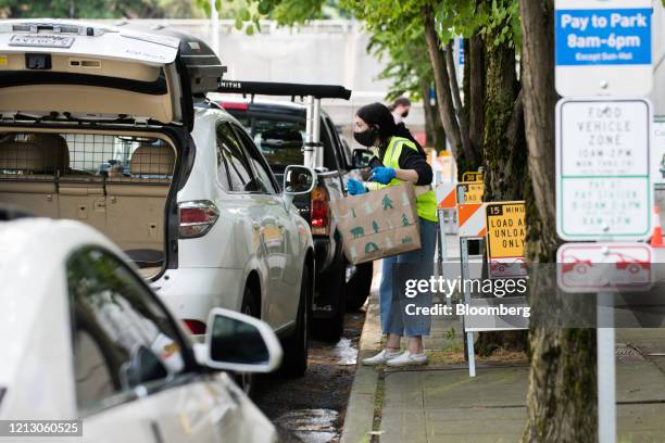 An employee assists a customer with contactless curbside pickup at the Recreational Equipment Inc. Flagship store in Seattle, Washington, U.S., on...