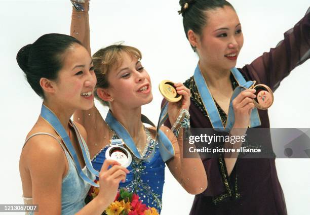 Nach der Kür im olympischen Eiskunstlauf-Wettbewerb am 20.2.1998 in der White Ring-Arena von Nagano zeigen die drei besten Damen bei der Siegerehrung...