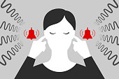 Woman is plugging her ears with fingers when suffering from tinnitus