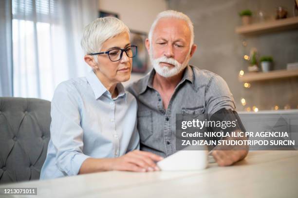 hoger paar dat hun bloeddruk tijdens pandemie covid-19 controleert. corona virus. - forced marriage stockfoto's en -beelden