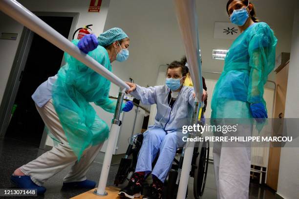 Patient who recovered from COVID-19 exercises with the assistance of two physiotherapists at the Puerta de Hierro University Hospital in Majadahonda...