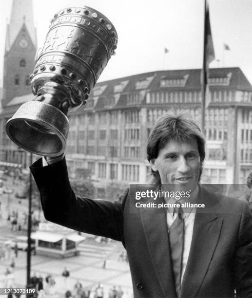 Hamburgs Abwehrspieler Manfred Kaltz hält den eroberten DFB-Fußballpokal am 21.6.1987 auf dem Balkon des Rathauses der Stadt bei der Siegesfeier für...