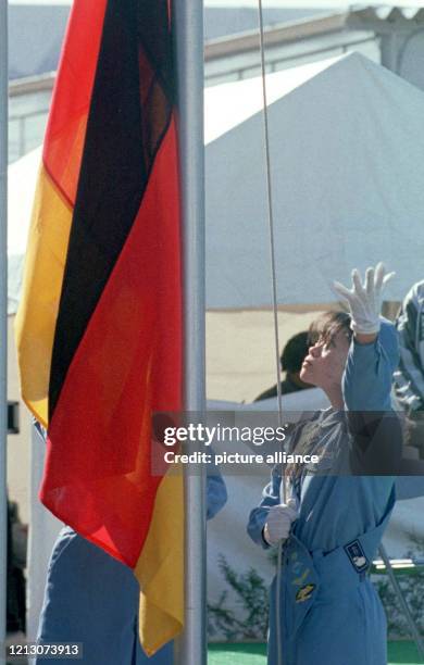 Ein Japanerin hißt am während der offiziellen Begrüßungszeremonie für das deutsche Team im Olympischen Dorf von Nagano die deutsche Fahne. Elf...