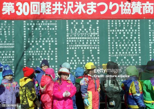 Japanische Kinder warten, in warmer Winterkleidung "verpackt", am 30.1.1998 in Karuizawa darauf, zusammen mit ihrer Betreuerin die von über 30...