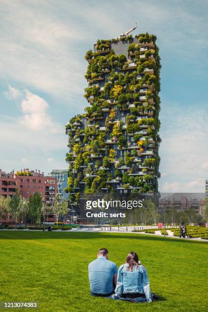 young couple enjoy and relaxing at park in milano, italy - bosco verticale milano stock pictures, royalty-free photos & images