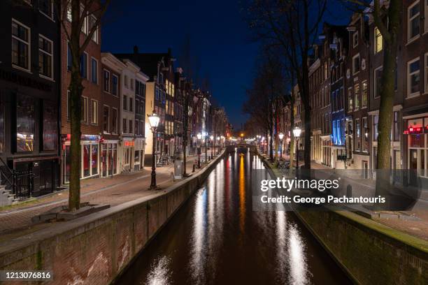 empty streets and shops in the red light district in amsterdam - amsterdam canal stockfoto's en -beelden