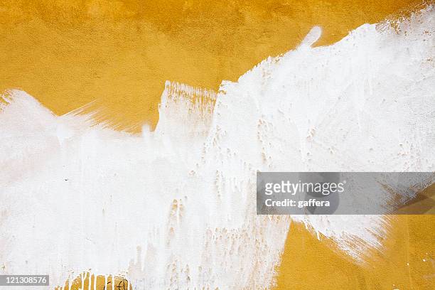 a yellow wall splashed with white paint - yellow wall stockfoto's en -beelden