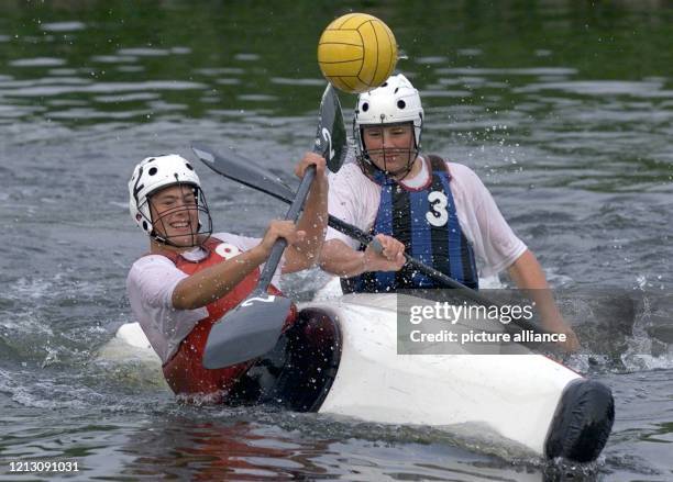 Mit Helm und Gesichtsschutz kämpfen die Kanu-Polo-Spieler Roman und Julian beim Training auf der Ruhr in Essen um den Ball. . Auf einer Spielfläche...