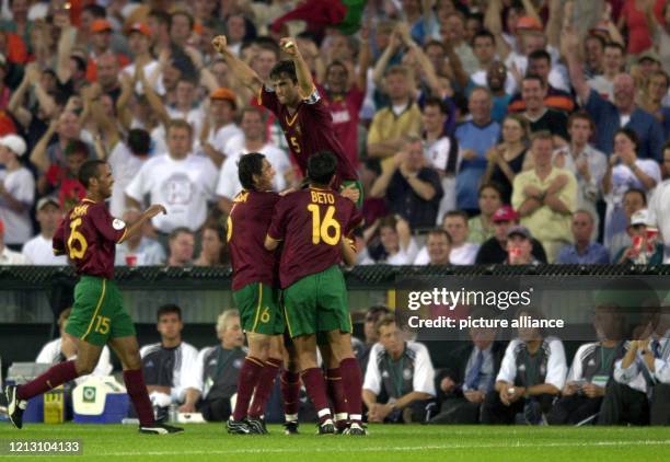 Die portugiesischen Spieler Francisco Costinha , Paulo Sousa und Beto liegen sich mit ihrem Torschützen Sergio Conceicao jubelnd in den Armen, und...