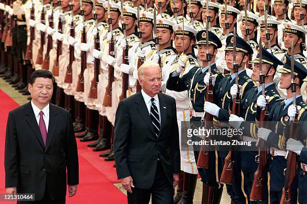 Chinese Vice President Xi Jinping accompanies U.S. Vice President Joe Biden to view an honour guard during a welcoming ceremony inside the Great Hall...
