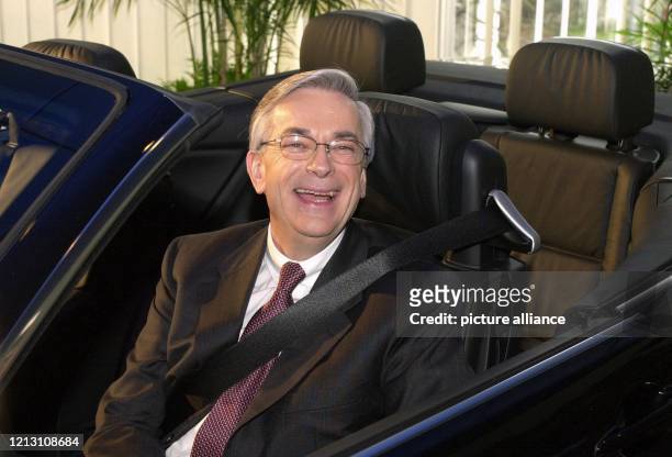Fröhlich schaut BMW-Vorstandschef Joachim Milberg am 28.3.2000 beim Fototermin nach der Bilanzpressekonferenz in München aus einem Cabriolet der 3-er...