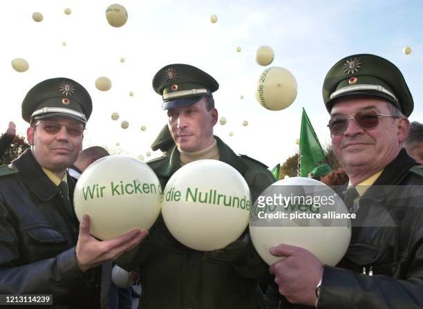 Wir kicken die Nullrunde 2000 weg steht auf den Luftbällen, die drei Polizisten am während einer Protestkundgebung in Berlin zeigen. Rund 1000 Beamte...