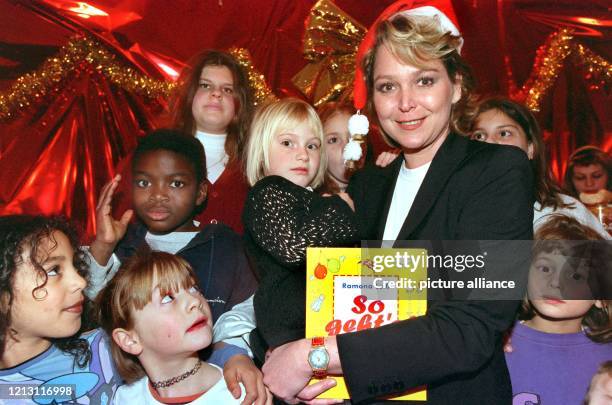 Ausgestattet mit einer knallroten Weihnachtsmann-Zipfelmütze, wird die Fernseh-Moderatorin Ramona Leiß am in einer Münchner Discothek von Kindern...