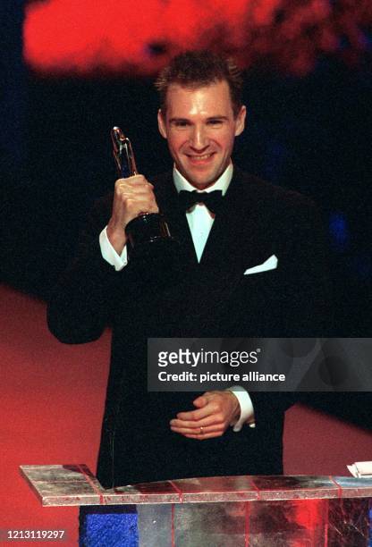 Strahlend zeigt der britische Schauspieler Ralph Fiennes am 4.12.1999 in Berlin den Europäischen Filmpreis, den er als bester europäischer...