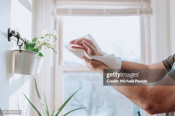 persoon drogen handen met papieren handdoeken om ziekte verspreiding te voorkomen, covid-19 - hand wringing stockfoto's en -beelden