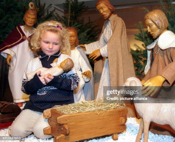 Zwischen den Figuren einer Weihnachtskrippe wiegt die kleine Frederike im Krippenmuseum Telgte liebevoll das hölzerne Jesuskind . Wenn die Stimmung...
