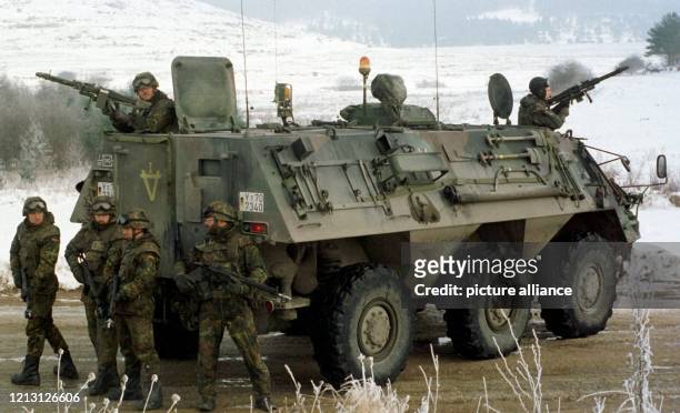 Auf dem Truppenübungsplatz im bayerischen Hohenfeld bewachen Bundeswehrsoldaten ihren Transportpanzer "Fuchs" . Die schon lange schwelende...