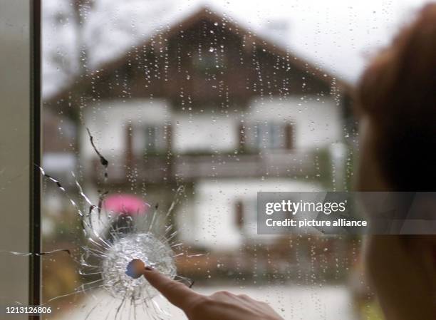 Eine Patientin betrachtet am 3.11.1999 im Bad Reichenhaller Krankenhaus ein Einschussloch in einem Fenster, das sich genau gegenüber dem Haus...