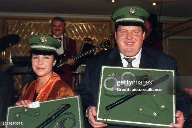Die Schauspieler Ottfried Fischer und Katerina Jacob posieren am 9.10.1999 beim "Ball der Polizei" in München mit Polizeimützen auf ihrem Kopf; in...