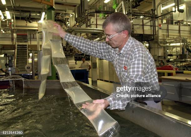 In Plastikfolie verschweißten Klebstoff kontrolliert ein Mitarbeiter am in der Klebstoff-Produktion der Firma Henkel in Düsseldorf. Der bei hohen...