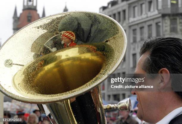 In der mit Regentropfen benetzten Tuba des Allgäuer Bläsers Peter Arnold spiegelt sich am 8. Januar 1999 auf dem Münchner Marienplatz eine rote...