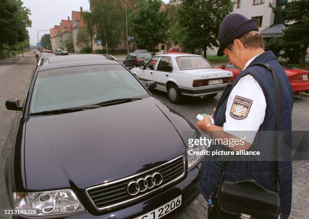 Die bei der Münchner Polizei angestellte Politesse Renate Westermeier stellt am 16.9.1999 einen Strafzettel für einen Falschparker aus.