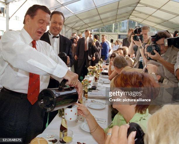 Hier bedient der Chef persönlich: Bundeskanzler Gerhard Schröder schenkt seinen Frühstücksgästen im Garten des Berliner Kanzleramtes am 12.9.1999...