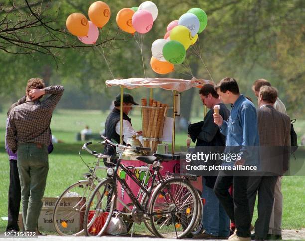 Bei strahlender Sonne genießen einige Besucher des Münchener Englischen Gartens am 28.4.1999 ein kaltes Eis. Viele Spaziergänger und Fahrradfahrer...