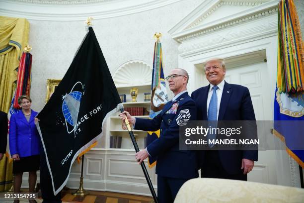 Space Force Senior Enlisted Advisor CMSgt Roger Towberman, with US President Donald Trump, presents the US Space Force Flag on May 15 in the Oval...