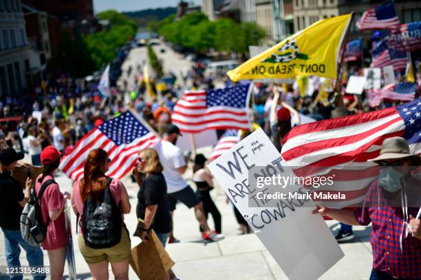 Demonstrator holds a placard stating "WE ARE NOT THE COWARDS" during a rally outside the Pennsylvania Capitol Building to protest the continued...