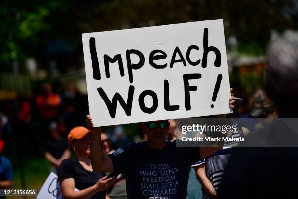 Demonstrator holds a sign stating "Impeach Wolf!" during a protest rally against Pennsylvania Governor Tom Wolf outside the State Capitol Building...