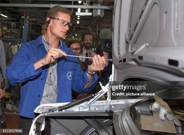 Der Formel 1-Pilot David Coulthard schraubt am 28.7.1999 im Mercedes-Werk Sindelfingen in Monteurskluft eine Schraube an einem Modell der S-Klasse...