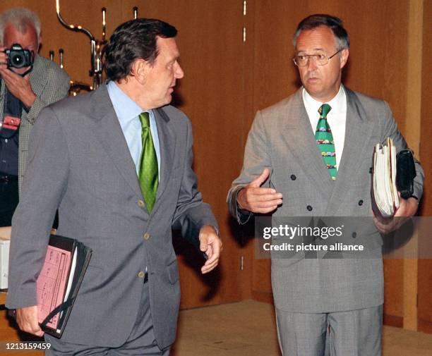 Mit Aktenpaketen unter den Armen kommen Bundeskanzler Gerhard Schröder und Bundesfinanzminister Hans Eichel am 21.7.1999 gemeinsam zur...