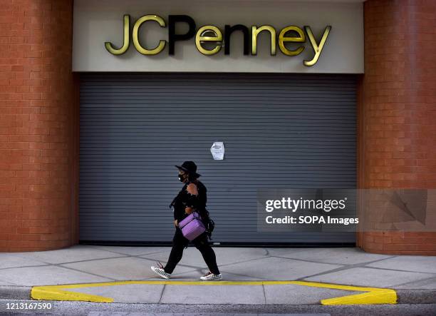 Woman walks by a JC Penney store that was temporarily closed on the day the company filed for bankruptcy protection and announced it would be closing...