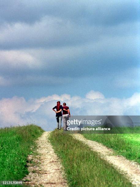 Eine Frau und ein Mädchen nutzen das freundliche Wetter am 20.6.1999 zu einem Spaziergang auf einem Feldweg im oberbayerischen Deining . Auf die...