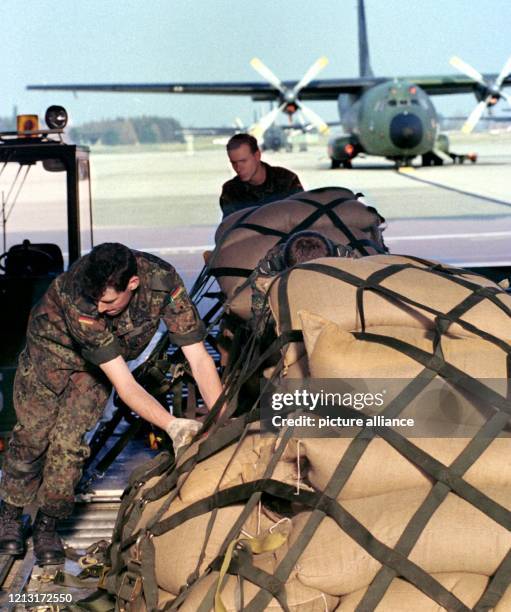 Bundeswehrsoldaten befestigen am 30.3.1999 auf dem bayerischen Fliegerhorst Penzing bei Landsberg/ Lech Hilfsgüter auf Paletten, die dann mit...