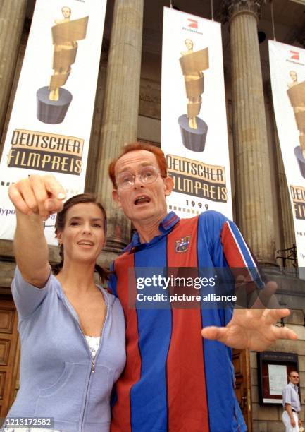 Lachend zeigt Eiskunstlauf-Star Katarina Witt am 16.6.1999 vor der Deutschen Staatsoper in Berlin auf die Fotografen, während der Kabarettist Piet...
