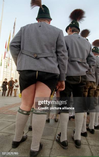 Ein bayerischer Jodler in einer kurzen Lederhose steht anläßlich der Grünen Woche in Berlin neben den Mitgliedern der Allgäuer Trachtengruppe in...