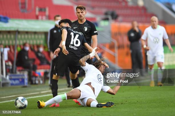 Kevin Mbabu of VfL Wolfsburg is fouled by Ruben Vargas of FC Augsburg during the Bundesliga match between FC Augsburg and VfL Wolfsburg at WWK-Arena...