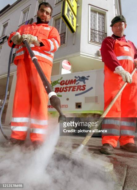 Zwei Mitarbeiter der Stadtreinigung rücken am 17.3.1999 in der Krefelder Innenstadt mit 180 Grad heißem Wasserdampf und Besen Kaugummi-Rückständen zu...