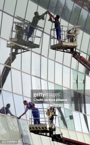 Von Hubwagen aus reinigen zwei Arbeiter am 3.5.2000 die Glasfassade des deutschen Pavillons auf dem Expo-Gelände in Hannover. Die halbrunden, nach...