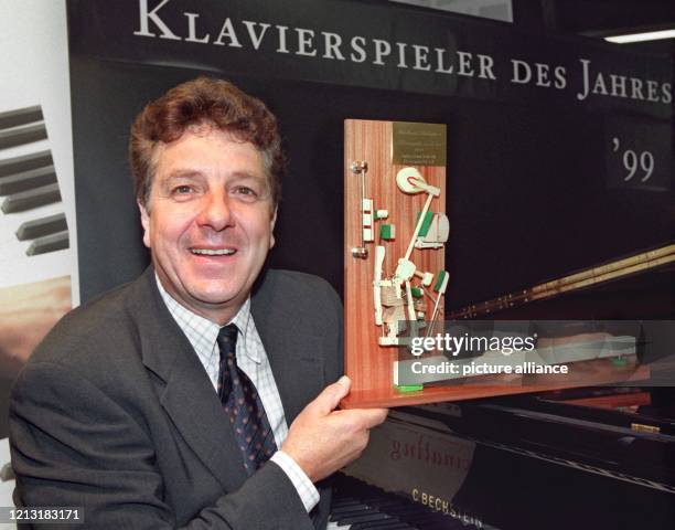 Stolz präsentiert Michael Schanze am 4.3.1999 in Frankfurt seinen Preis, mit dem er zuvor als "Klavierspieler des Jahres" ausgezeichnet worden ist....