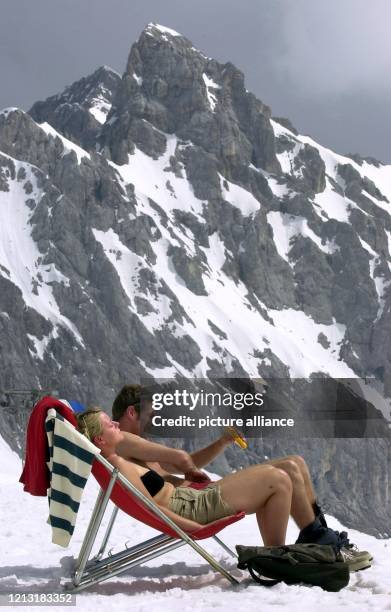 Vorfreude auf den Sommer: Vor der Kulisse der Höllentalspitze sonnt sich am 1.5.2000 ein Pärchen. Die beiden haben sich samt Liegestuhl ein Plätzchen...
